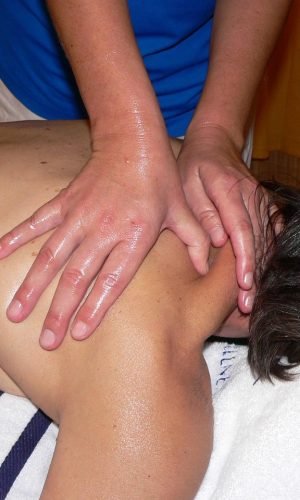 Crowd crossing a London street with iconic red buses in motion, capturing urban life.